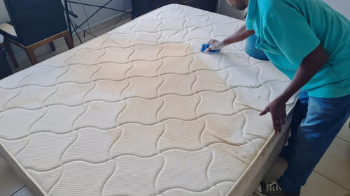 Hand scrubbing a mattress.